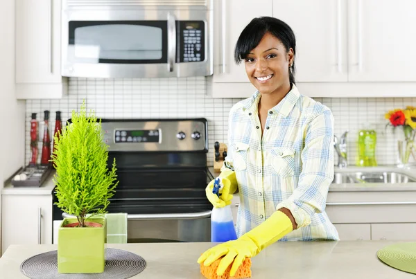 Νεαρή γυναίκα καθαρίζει κουζίνα — Φωτογραφία Αρχείου
