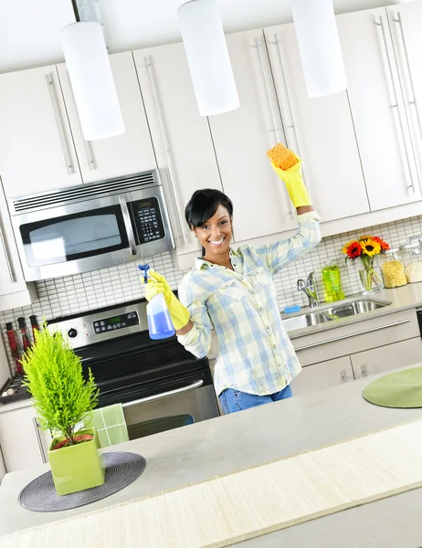 Mladá žena čištění kuchyně — Stock fotografie