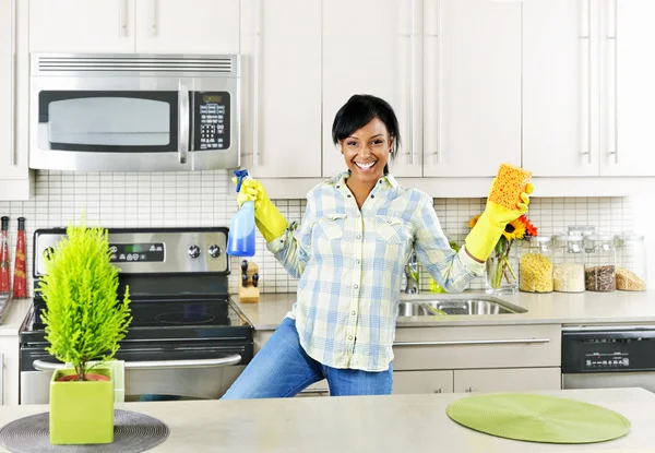 Mladá žena čištění kuchyně — Stock fotografie
