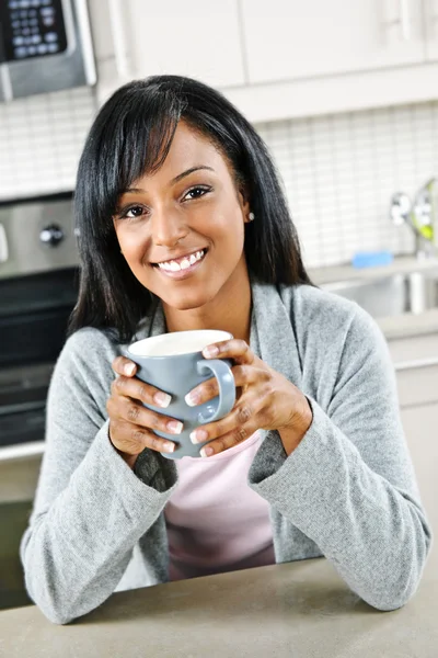 Kobieta w kuchni z filiżanką kawy — Zdjęcie stockowe