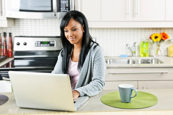 Mujer usando ordenador en la cocina — Foto de Stock