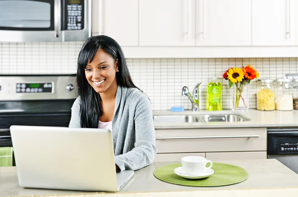 Frau benutzt Computer in Küche — Stockfoto