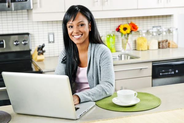 Mulher usando o computador na cozinha — Fotografia de Stock