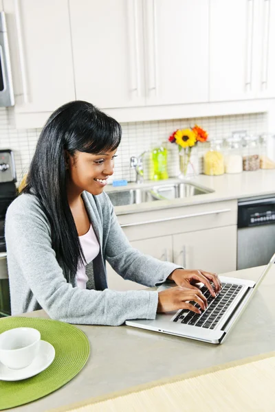 Giovane donna che utilizza il computer in cucina — Foto Stock