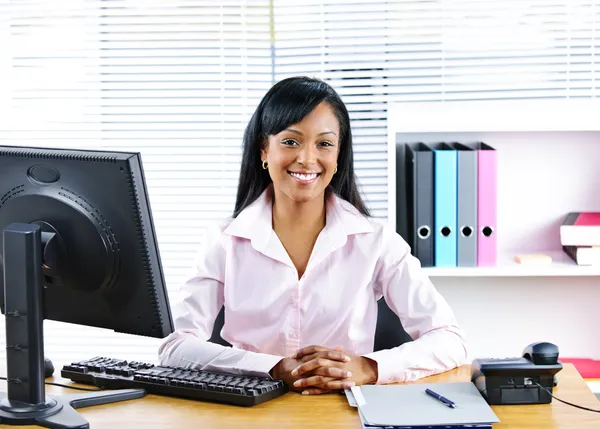Улыбающаяся чернокожая деловая женщина за столом — стоковое фото