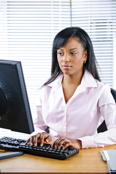 Serious black businesswoman at desk