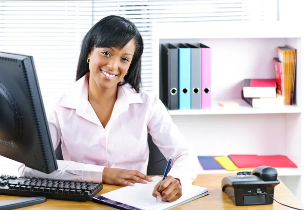 Sorridente donna d'affari nera alla scrivania — Foto Stock