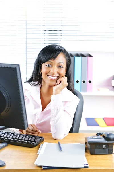 Glimlachende zakenvrouw in zwarte aan balie — Stockfoto