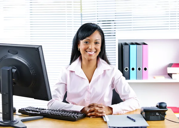 Leende svart affärskvinna på skrivbord Royaltyfria Stockbilder