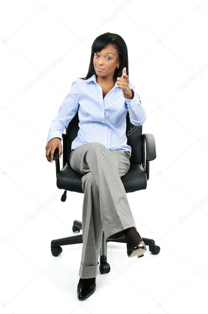 Businesswoman pointing sitting on office chair