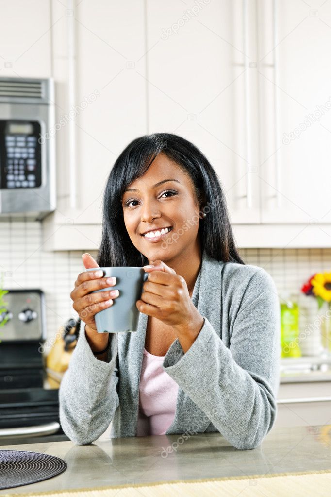 Woman in kitchen with coffee cup