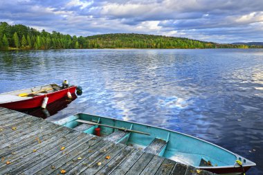 Rowboats on lake at dusk clipart