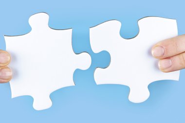 Fingers holding jigsaw puzzle pieces clipart