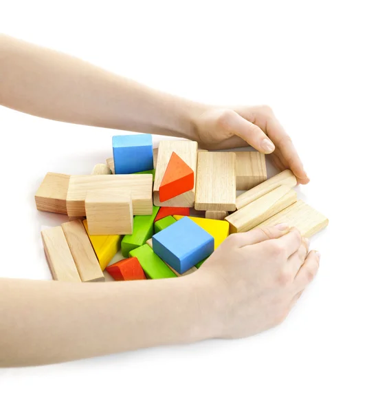 Mãos com brinquedos de bloco de madeira — Fotografia de Stock