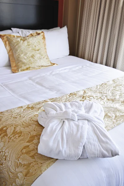 Pocket ess primeバスローブ付きのホテルのベッド — ストック写真