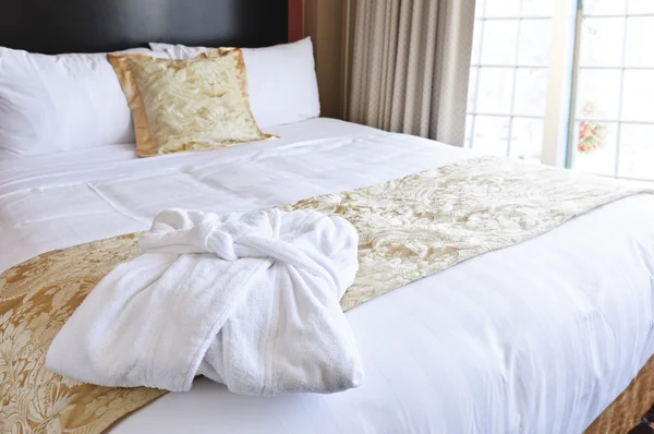 Pocket ess primeバスローブ付きのホテルのベッド — ストック写真