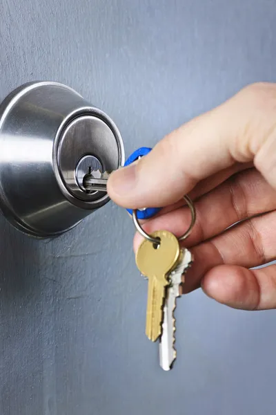 Hand sleutels in slot invoegen — Stockfoto