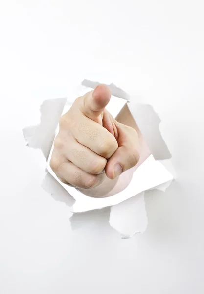 Dedo apuntando a través de un agujero en papel — Foto de Stock