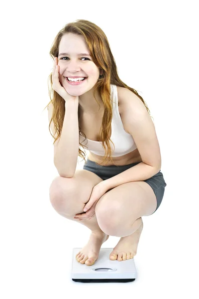 Smiling young girl on bathroom scale — Stock Photo, Image