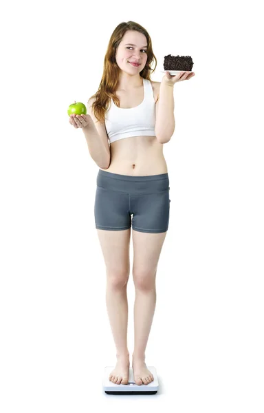 Jovencita en escamas sosteniendo manzana y pastel — Foto de Stock