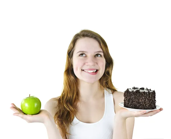 Молодая девушка держит яблоко и торт — стоковое фото