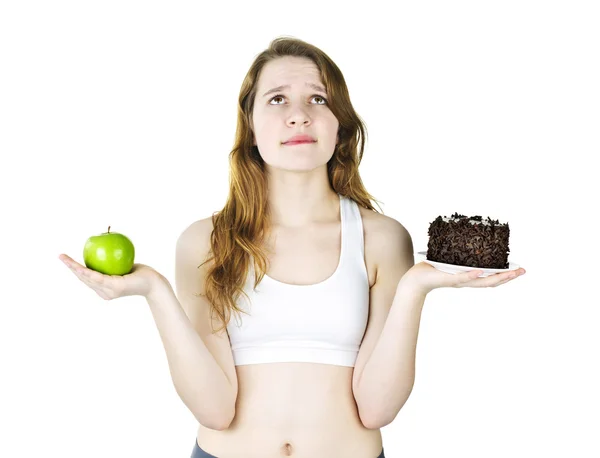 Chica joven sosteniendo manzana y pastel — Foto de Stock
