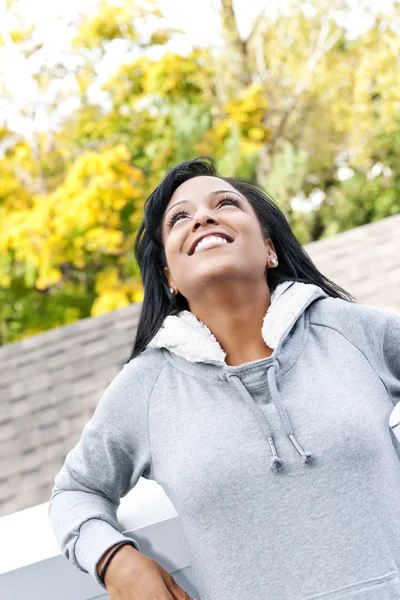 Glimlachend jonge vrouw buitenshuis opzoeken — Stockfoto