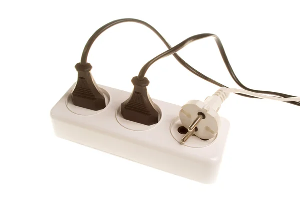 stock image Three white and black electrical plugs into the outlet