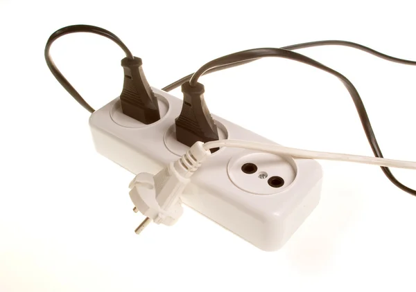 Drie witte en zwarte elektrische stekkers op witte stopcontact in de — Stockfoto