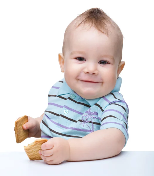 Ładny mały chłopiec trzyma pliki cookie i uśmiech — Zdjęcie stockowe