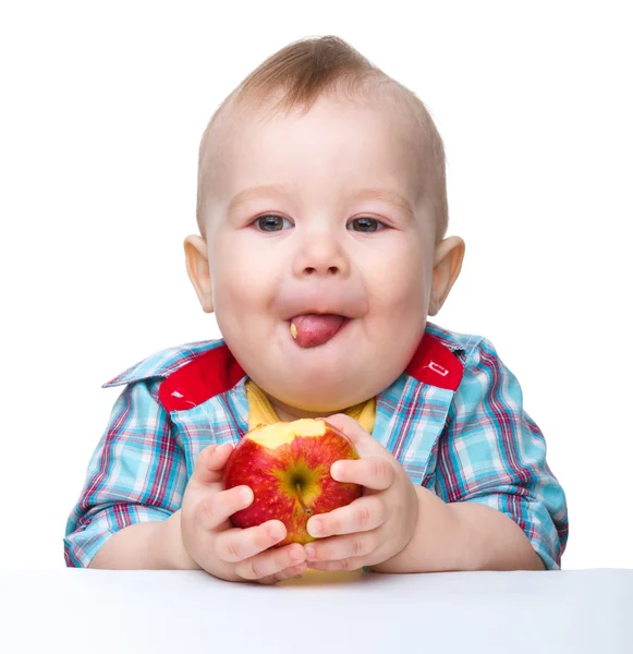 Pequeño niño está comiendo manzana roja —  Fotos de Stock