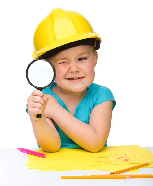 Cute little girl is looking through magnifier — Stock Photo, Image