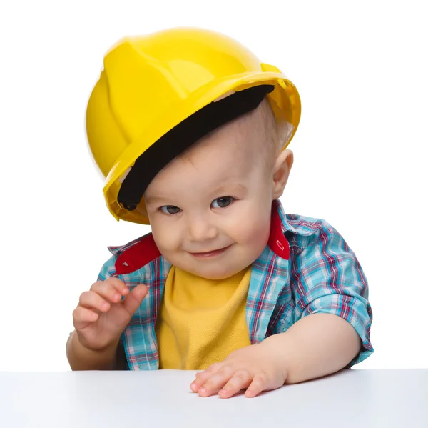 Cute little boy wearing oversized hard hat Stock Image