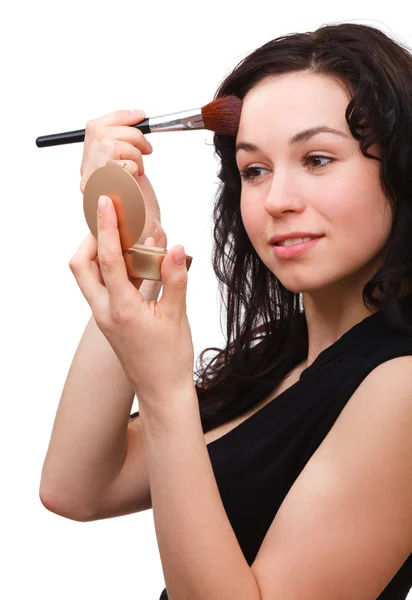 Girl is applying rouge while looking at mirror — Stock Photo, Image