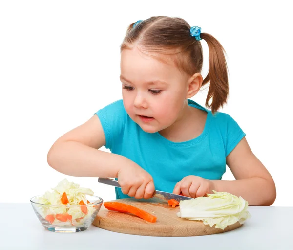 Petite fille coupe la carotte pour la salade — Photo