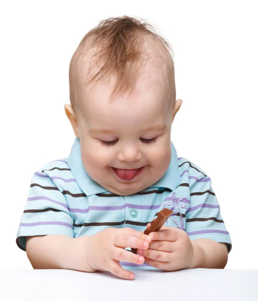 Menino bonito está segurando barra de chocolate e sorriso — Fotografia de Stock