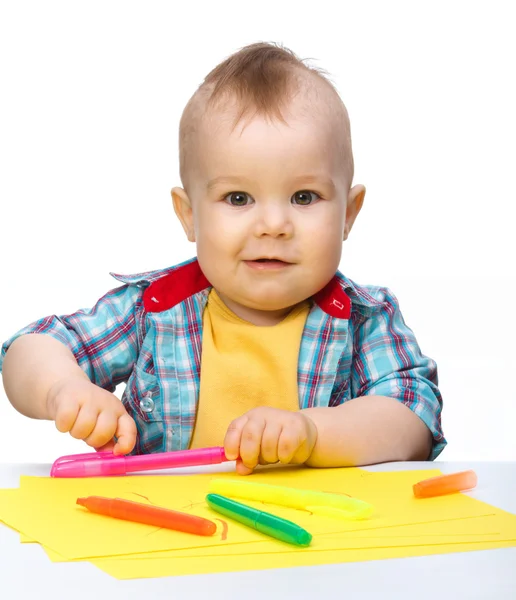 Šťastný chlapec hraje s barevnými značkami — Stock fotografie