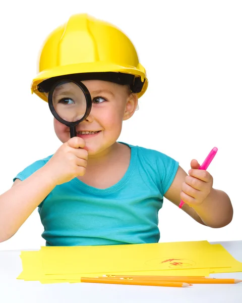 Cute little girl is looking through magnifier — Stock Photo, Image