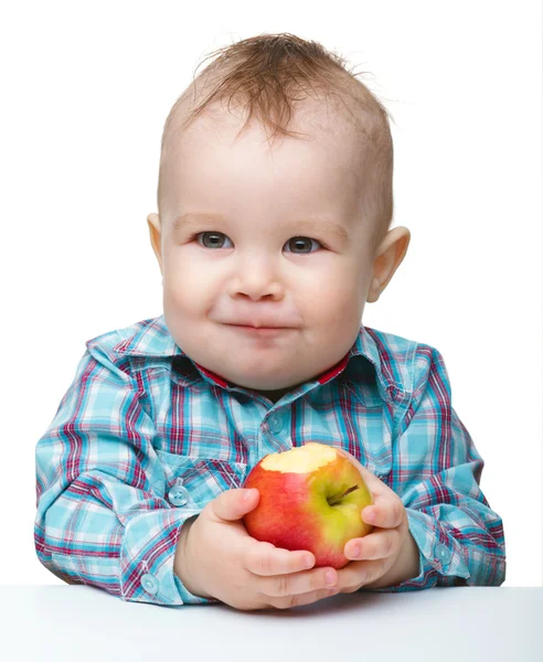 Pequeño niño está comiendo manzana roja —  Fotos de Stock
