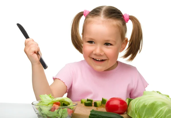 Kleines Mädchen schneidet Möhre für Salat — Stockfoto