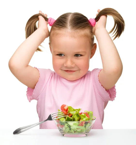 Söt liten flicka äter grönsakssallad — Stockfoto