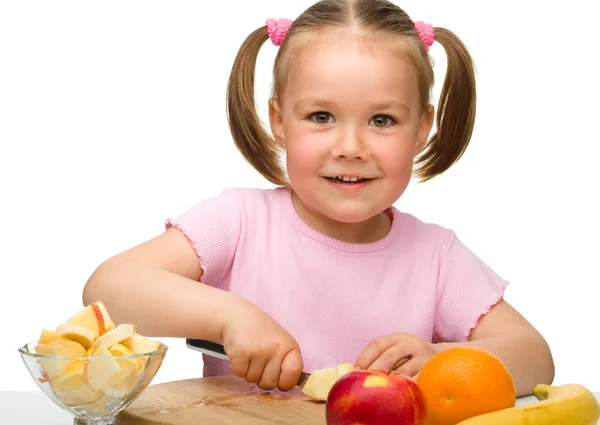 Little girl is cutting fruits for salad — Stock Photo, Image