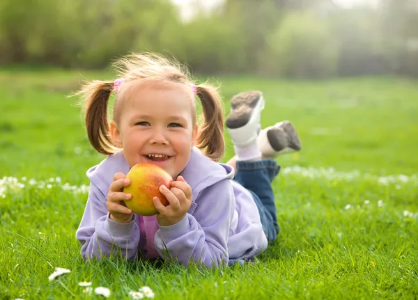 小さな女の子は緑の牧草地に敷設します。 — ストック写真