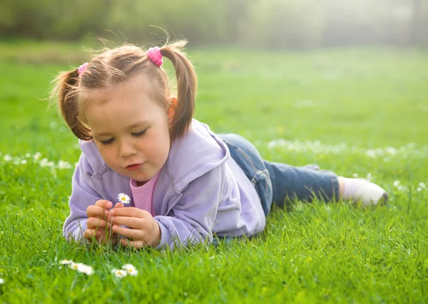 Niña está acostada en prado verde — Foto de Stock