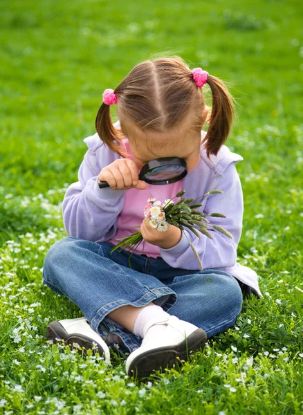 어린 소녀는 녹색 풀밭에 앉아 — 스톡 사진