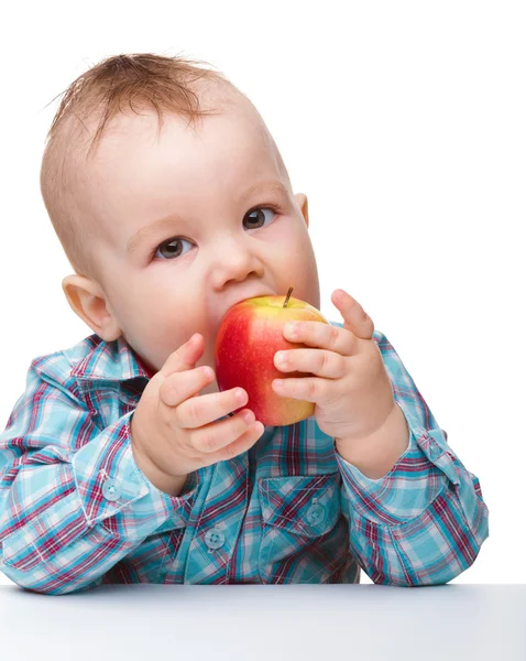 Criança está comendo maçã vermelha — Fotografia de Stock