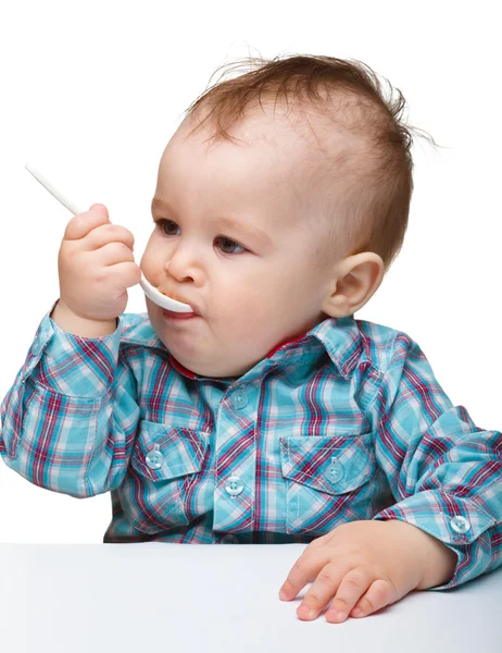 Ładny mały chłopiec jest gryzienie łyżka — Zdjęcie stockowe