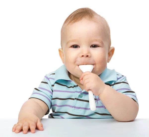 stock image Cute little boy is biting spoon