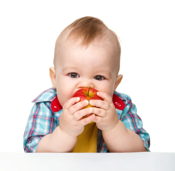Criança está comendo maçã vermelha — Fotografia de Stock