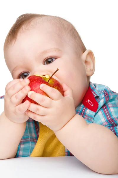小さな子供は赤いリンゴを食べています。 — ストック写真